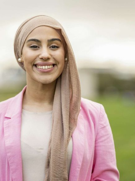 Portrait beautiful Middle Eastern woman with hijab with toothy smile looking at camera