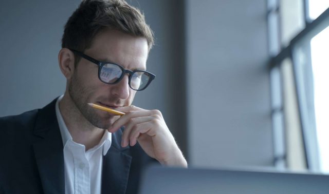 Serious german man executive dressed in formal clothes looking at laptop screen browsing internet